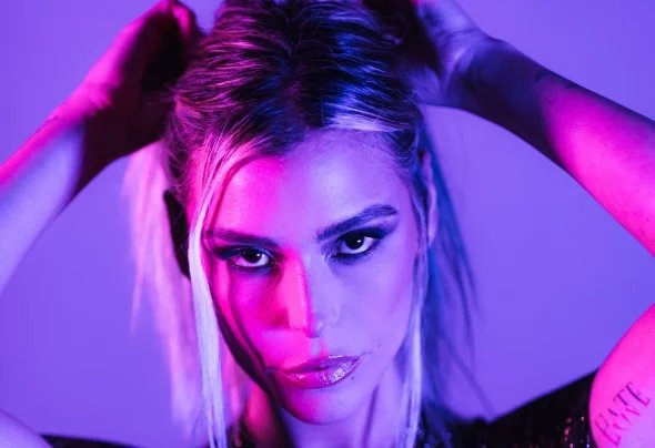 Sam Blacky artist photo in dramatic purple and pink neon lighting